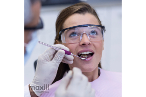 Woman patient receiving dental care while wearing protective eyewear